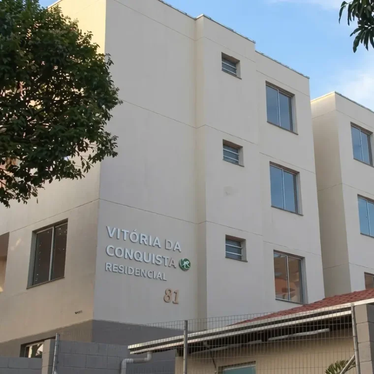 Fachada do Residencial Vitória da Conquista com prédios de apartamentos claros, cercamento frontal e área arborizada em Ipatinga