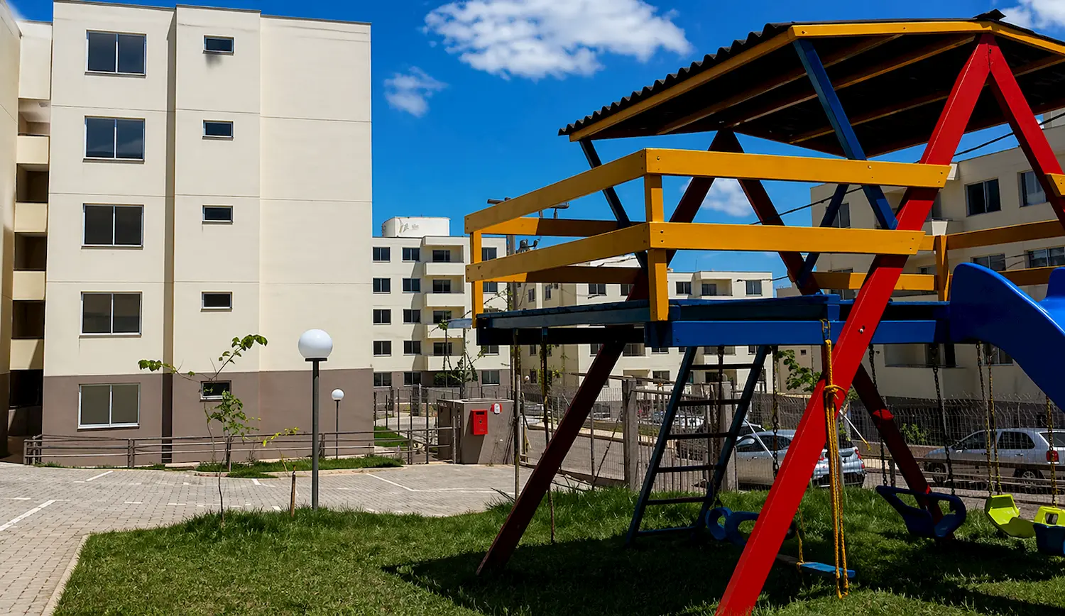 Conjunto habitacional com prédios residenciais e playground infantil em área comum no Residencial Recanto das Águas