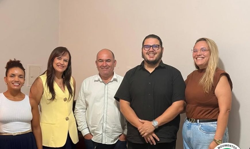 Cinco participantes posam para foto durante reunião em Caratinga, com faixa “Moradia digna é direito!” e logomarca da CMP Vale do Aço